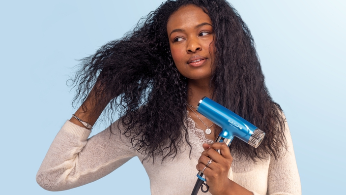 woman using a blue babylisspro hair dryer