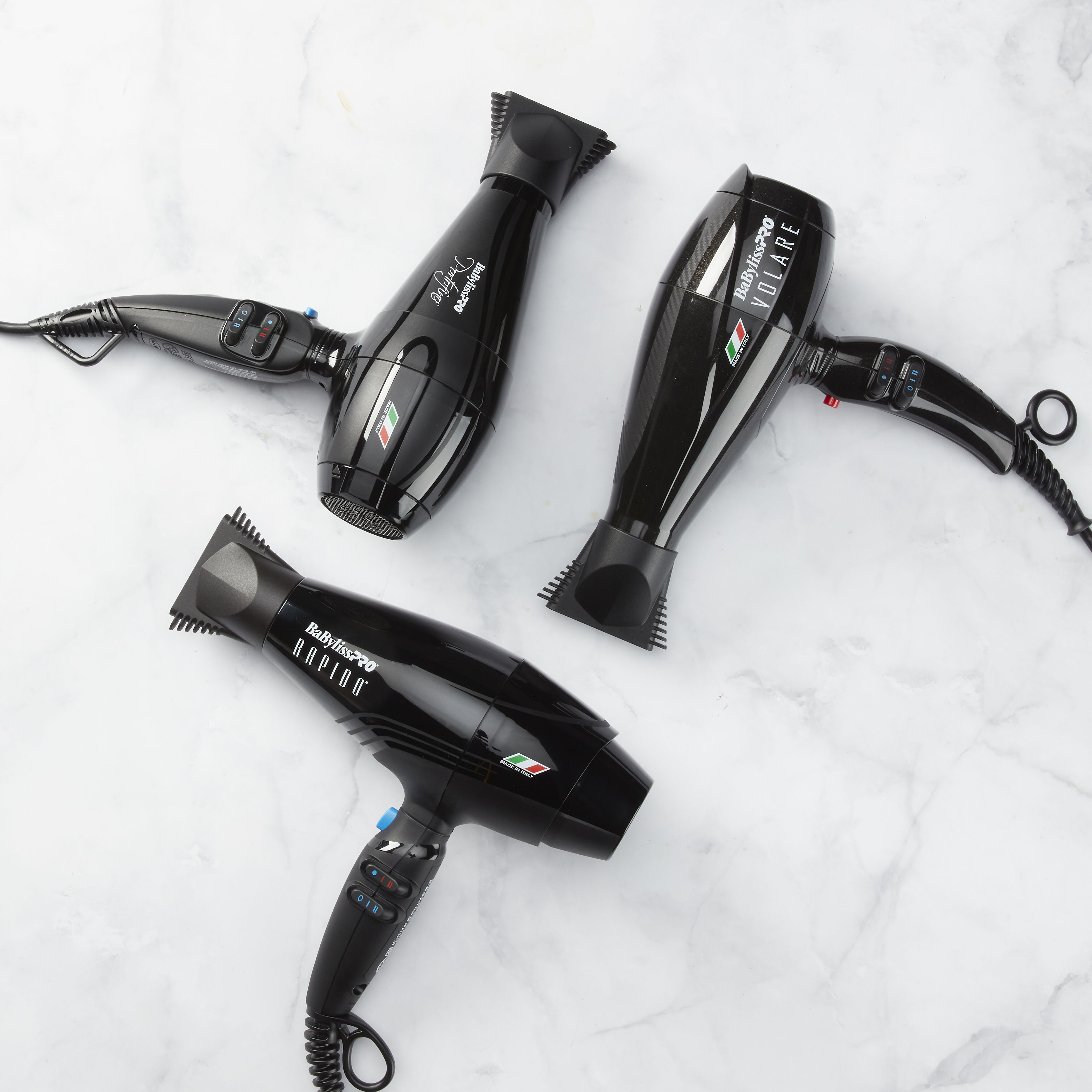 Image of 3 BaBylissPRO Hair Dryers in Black Laying on a Marble Background