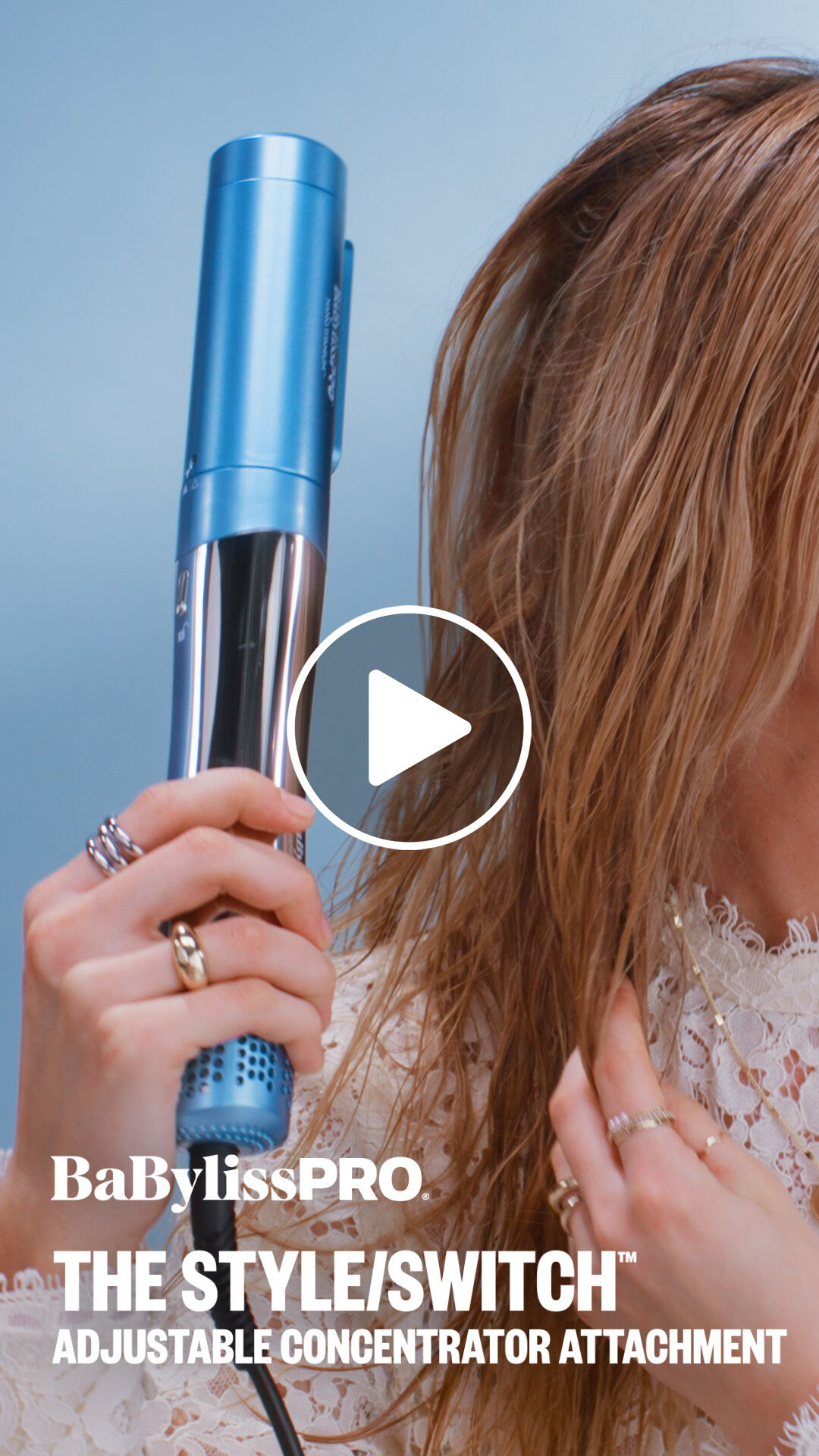 A woman with light blonde hair using a BaBylissPRO adjustable concentrator attachment to blow dry her hair with the style switch multi styler hair tool