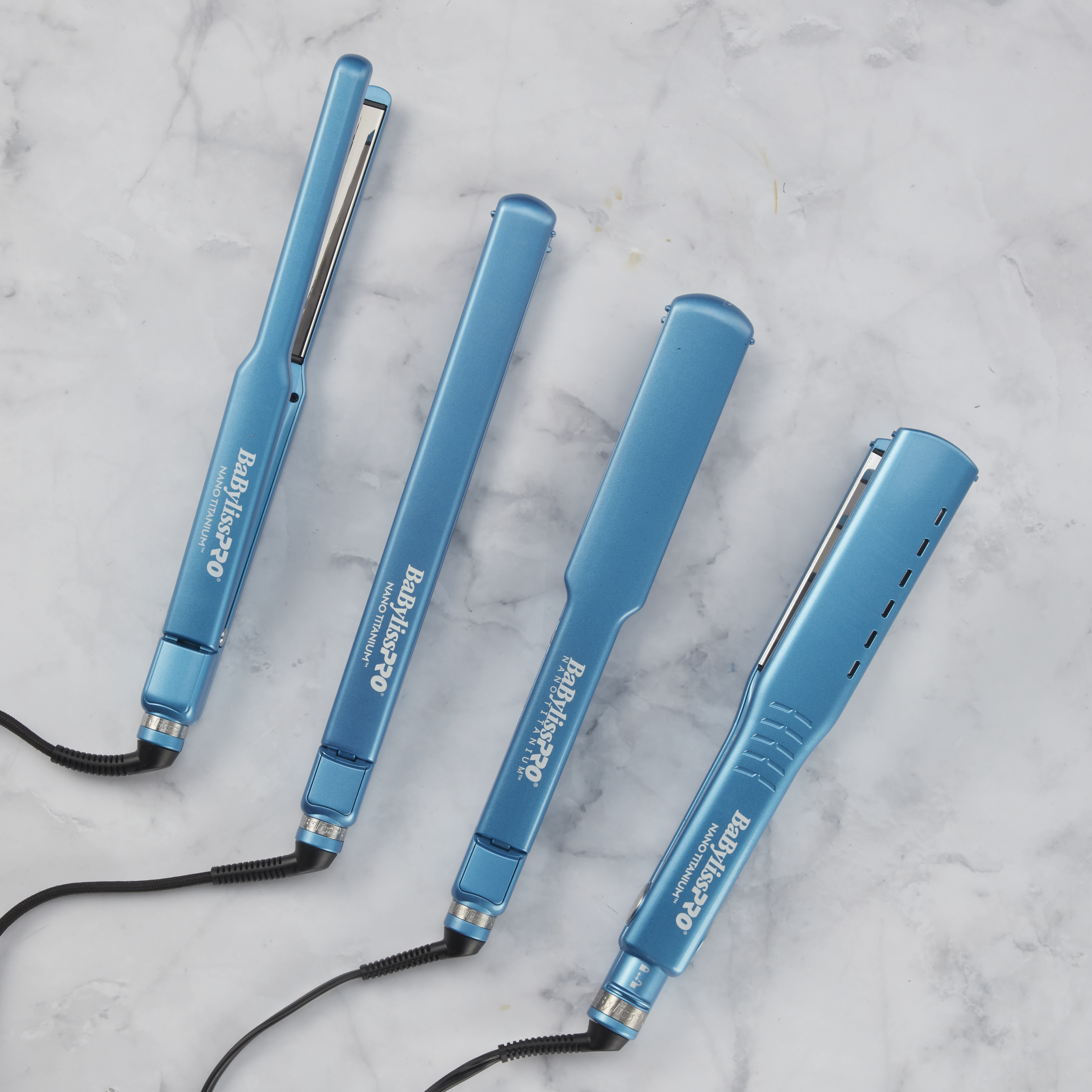 Image of 4 Nano Titanium Flat Irons in Blue laying on a marble background